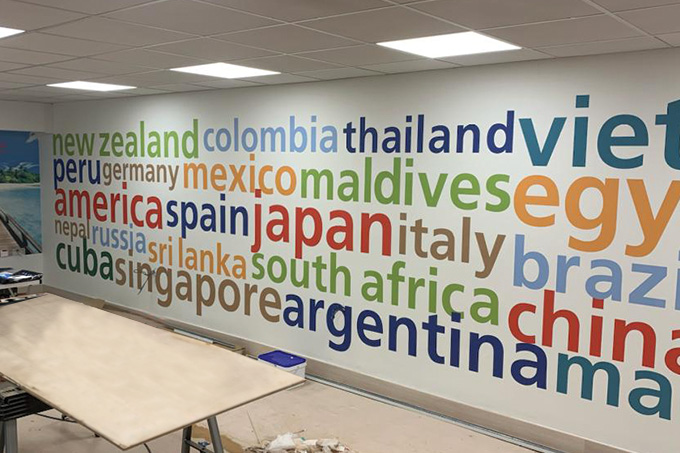 a feature wall in an office with different names of countries