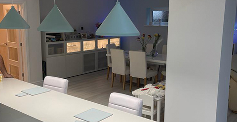 a kitchen painted in different whites and blue lampshades